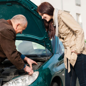 Car needs repair, man and woman examining motor. 